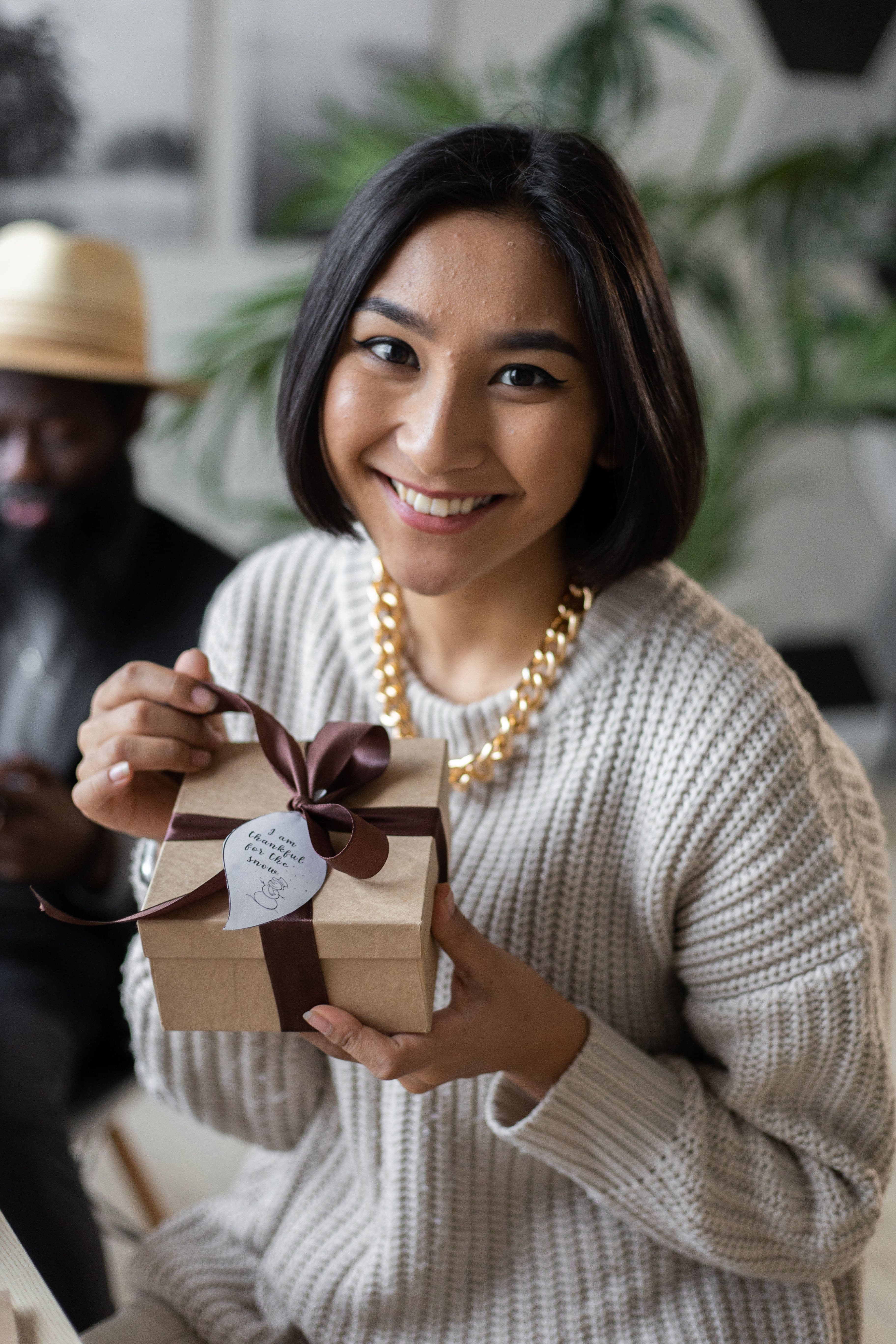 Cliente souriante en train d'ouvrir un cadeau reçu