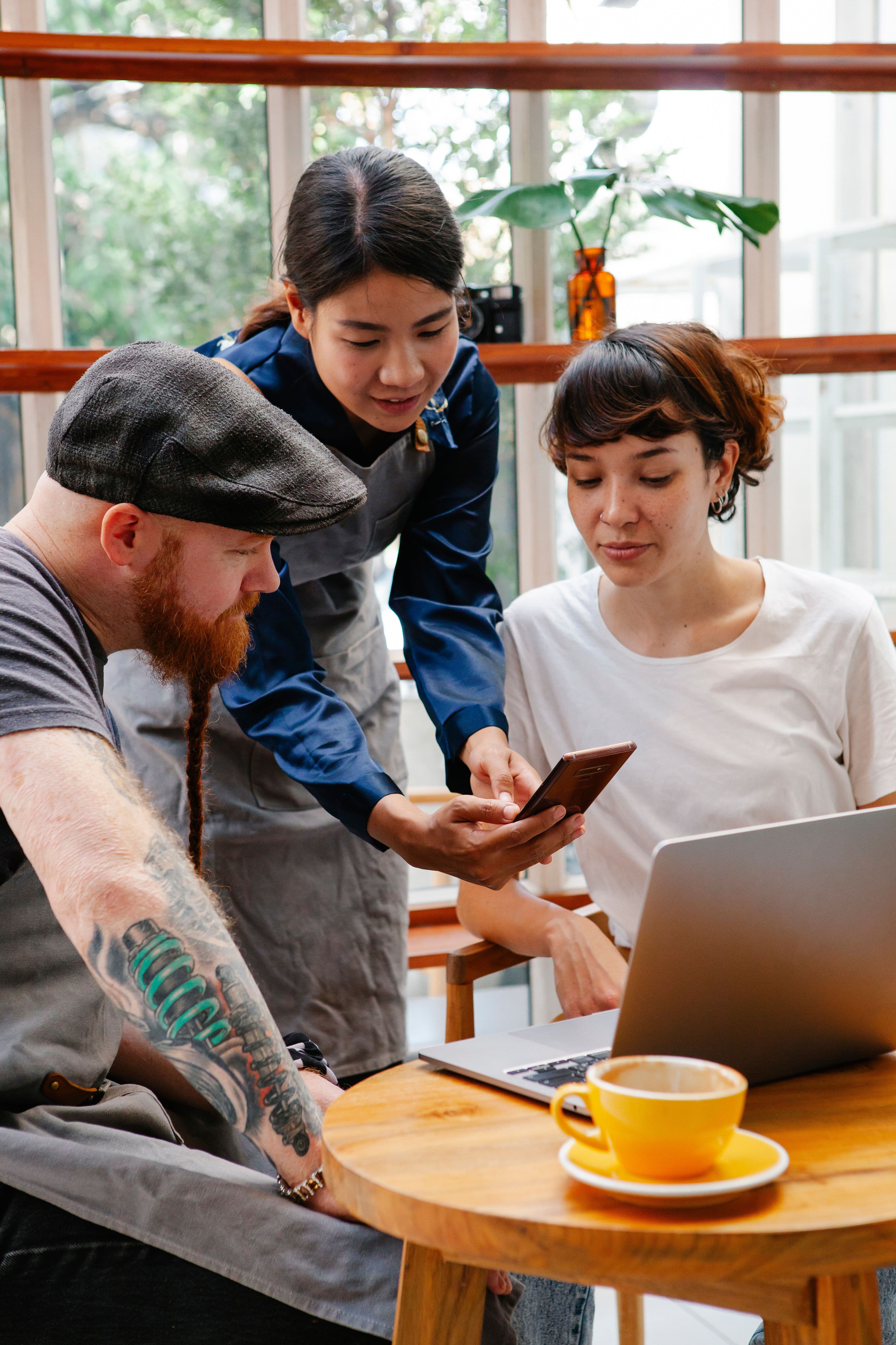 Équipe de restaurant réunie autour d'un téléphone pour valider un visuel