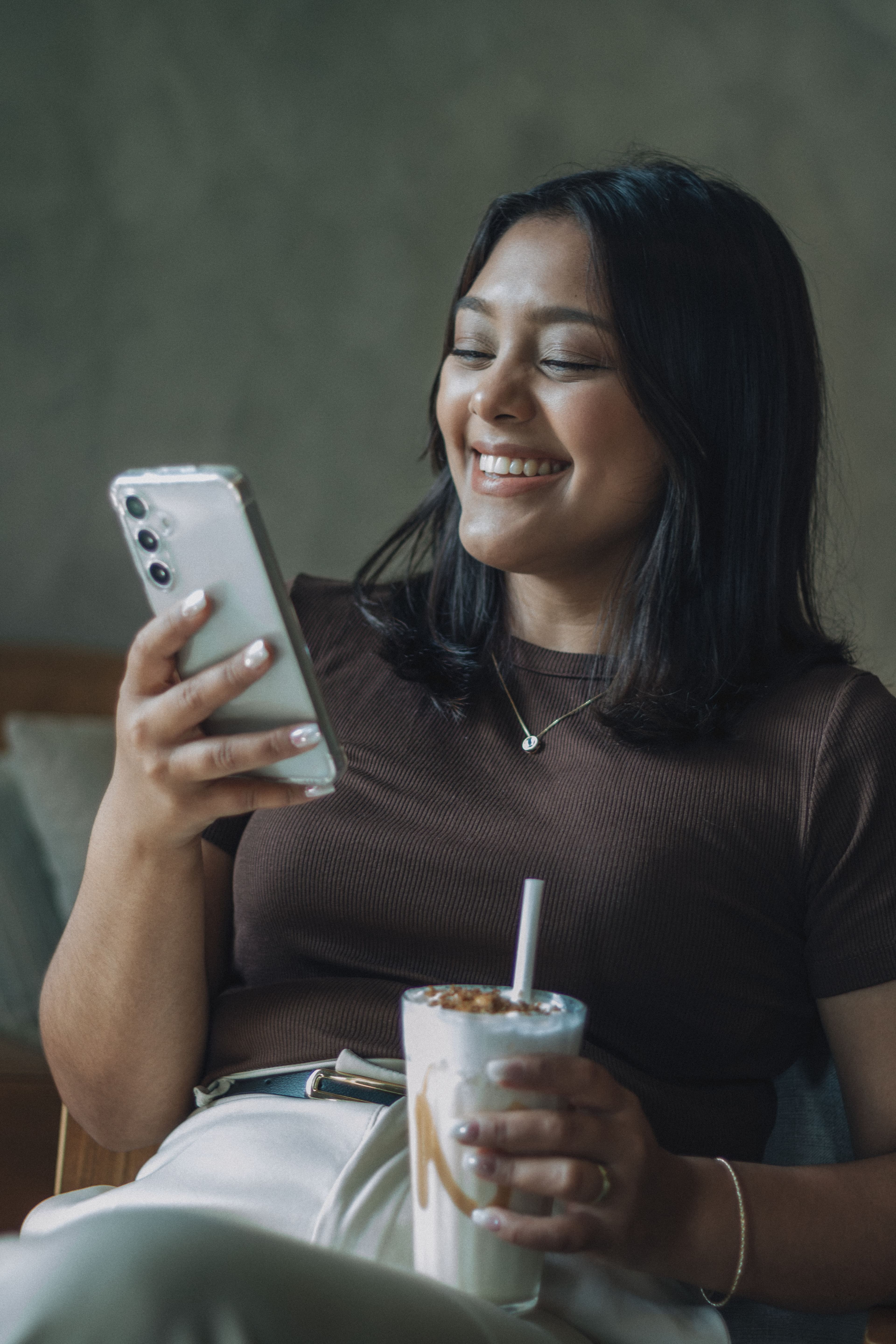 Cliente souriante en consultant une notification sur son téléphone